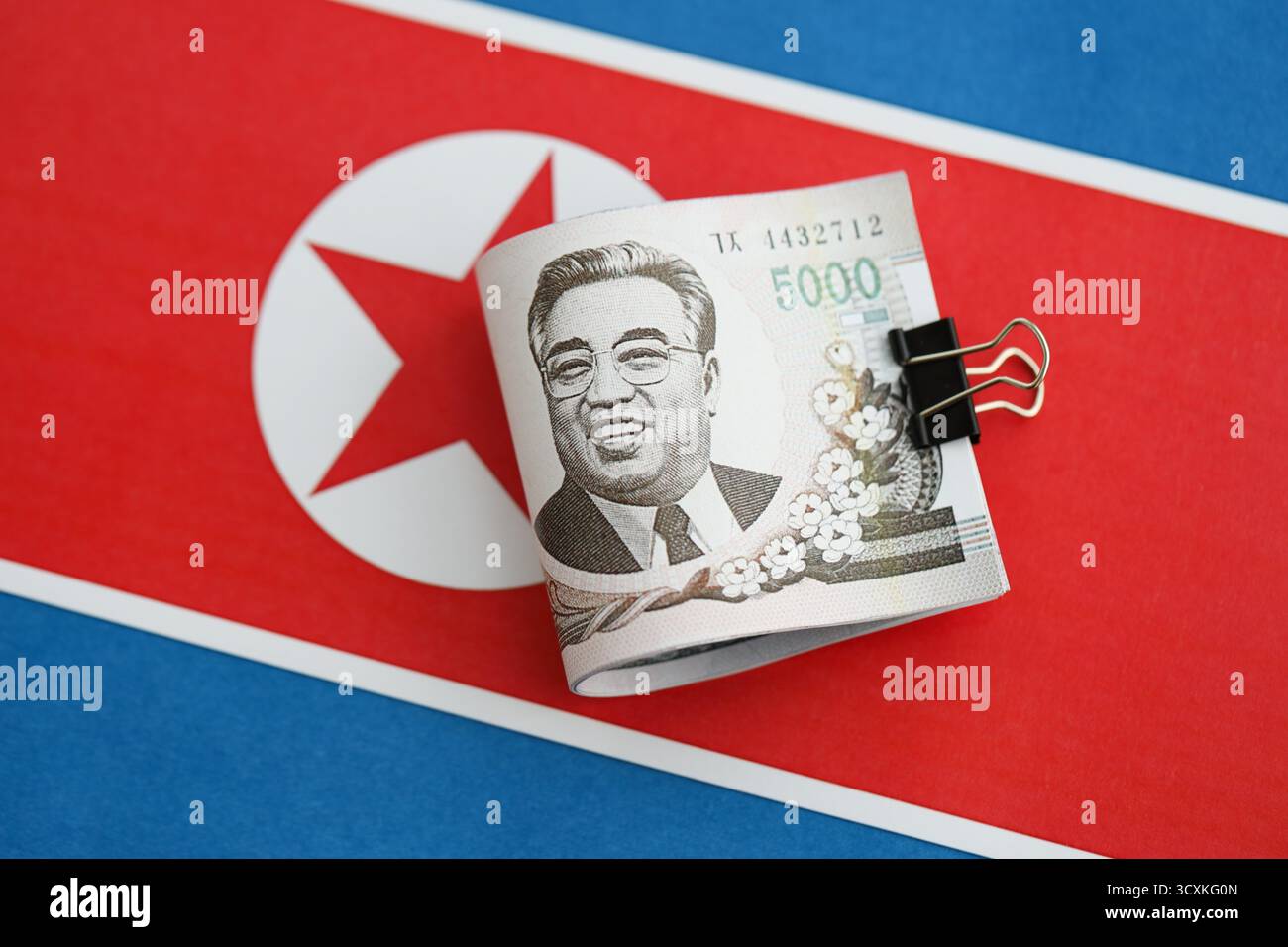 Nordkoreaner gewannen Geldscheine in großer Höhe lügen auf der Flagge der Volksrepublik Korea aus nächster Nähe. Finanz- und Bankkonzept Stockfoto