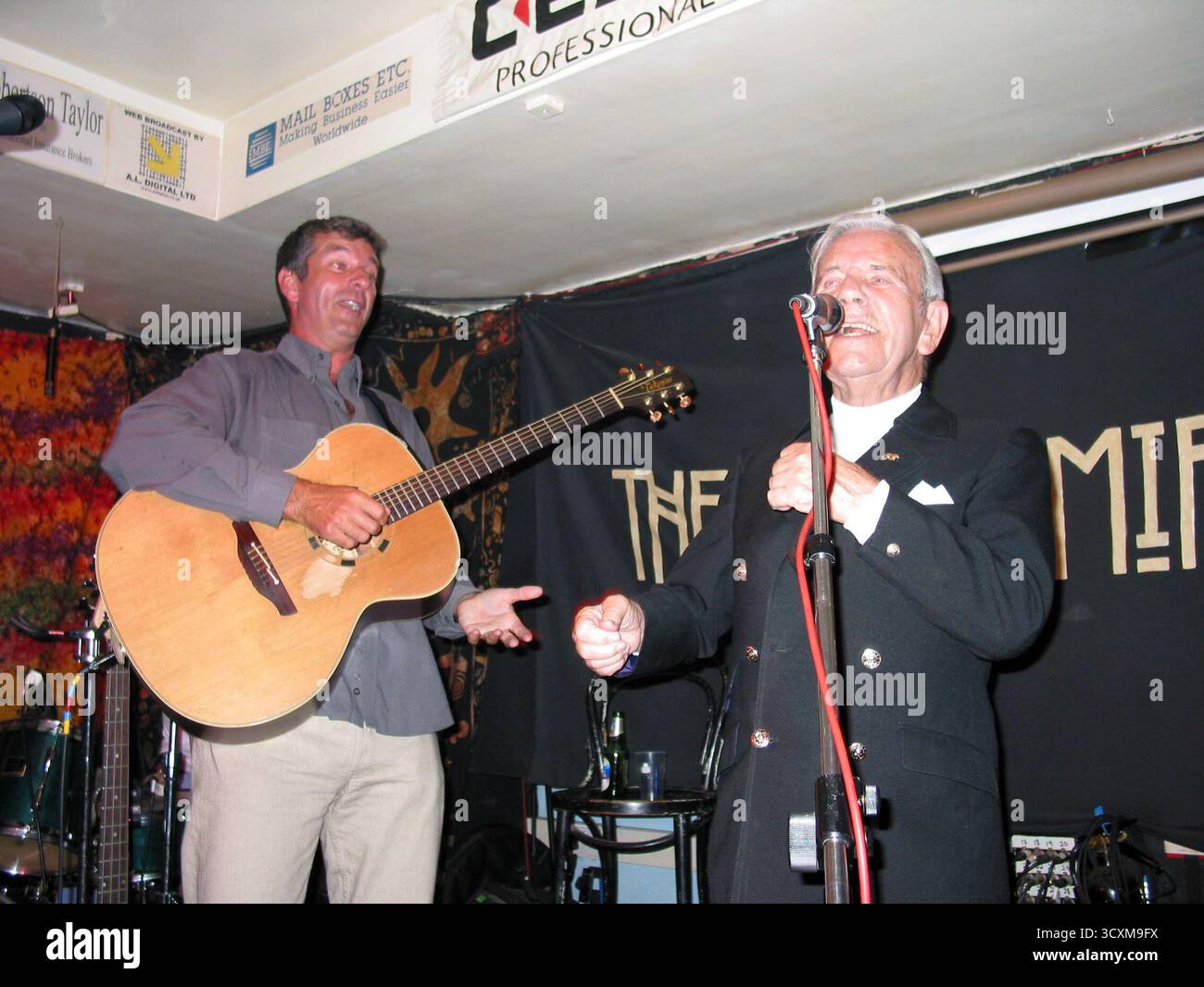 Tony Hawkes Launch des neuen Buches One Hit Wonderland, Kashmir Club, 31. Juli 2002 auf der Launchparty trat Tony Hawkes mit seiner Band auf, mit Sir Norman Wisdom (Gesang) und Sir Tim Rice (Spielzeugsaxophon), sowie Lucinda Labes und Eva Rice (Background Vocals) und Donald Rice (Toy Trompete) die Band spielte den albanischen Hit Big in Albanien. Sir Norman Wisdom sang auch einige seiner eigenen Hits aus der Vergangenheit, darunter Don't Laugh at Me 'Cause I'm A Fool, der 1954 ein Nummer-1-Hit war. Mit 87 hat Sir Norman immer noch eine fantastische Gesangsstimme und liebt es, aufzutreten Stockfoto Tony Hawkes Launch des neuen Buches One Hit Wonderland, Kashmir Club, 31. Juli 2002 auf der Launchparty trat Tony Hawkes mit seiner Band auf, mit Sir Norman Wisdom (Gesang) und Sir Tim Rice (Spielzeugsaxophon), sowie Lucinda Labes und Eva Rice (Background Vocals) und Donald Rice (Toy Trompete) die Band spielte den albanischen Hit Big in Albanien. Sir Norman Wisdom sang auch einige seiner eigenen Hits aus der Vergangenheit, darunter Don't Laugh at Me 'Cause I'm A Fool, der 1954 ein Nummer-1-Hit war. Mit 87 hat Sir Norman immer noch eine fantastische Gesangsstimme und liebt es, aufzutreten Stockfoto