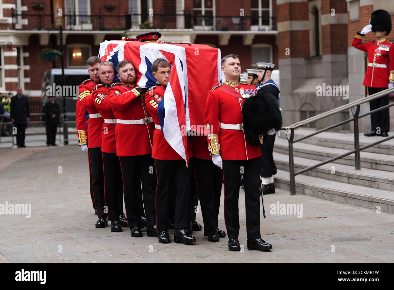Die Trägerpartei, bestehend aus Mitgliedern der walisischen Garde, trägt den Sarg, der mit einer Flagge von Union Jack gedeckt ist, zur Requiem-Messe für den ehemaligen Chef der Streitkräfte, Feldmarschall Lord Guthrie, in der Westminster Cathedral in London. Bilddatum: Mittwoch, 15. Oktober 2025. Stockfoto