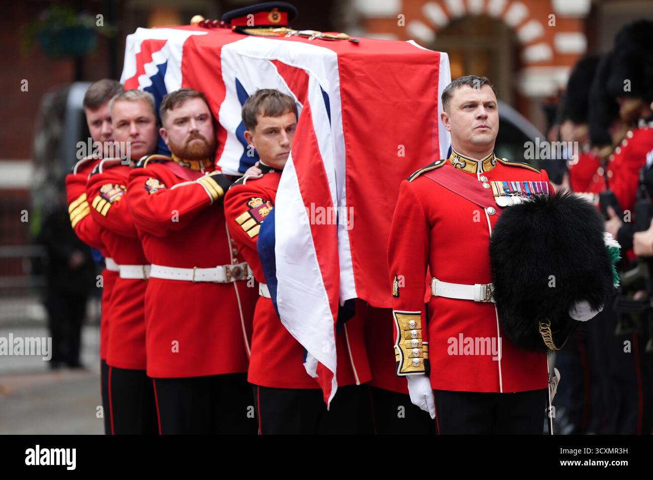 Die Trägerpartei, bestehend aus Mitgliedern der walisischen Garde, trägt den Sarg, der mit einer Flagge von Union Jack gedeckt ist, zur Requiem-Messe für den ehemaligen Chef der Streitkräfte, Feldmarschall Lord Guthrie, in der Westminster Cathedral in London. Bilddatum: Mittwoch, 15. Oktober 2025. Stockfoto