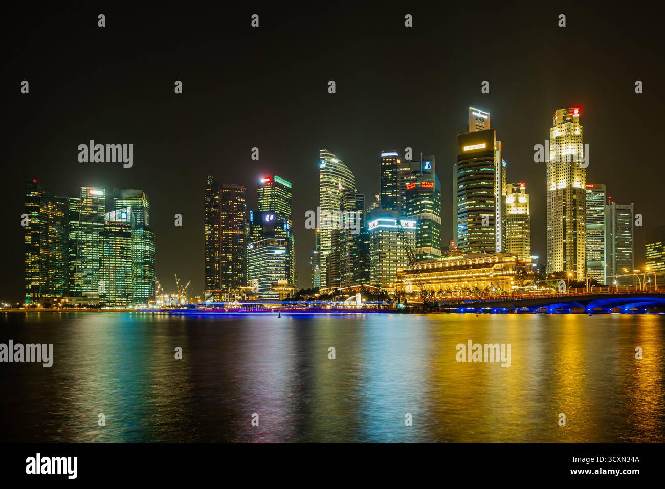 singapur - Downtown - Skyline des Finanzviertels mit Wolkenkratzern bei Nacht und Reflexen über dem Fluss Stockfoto