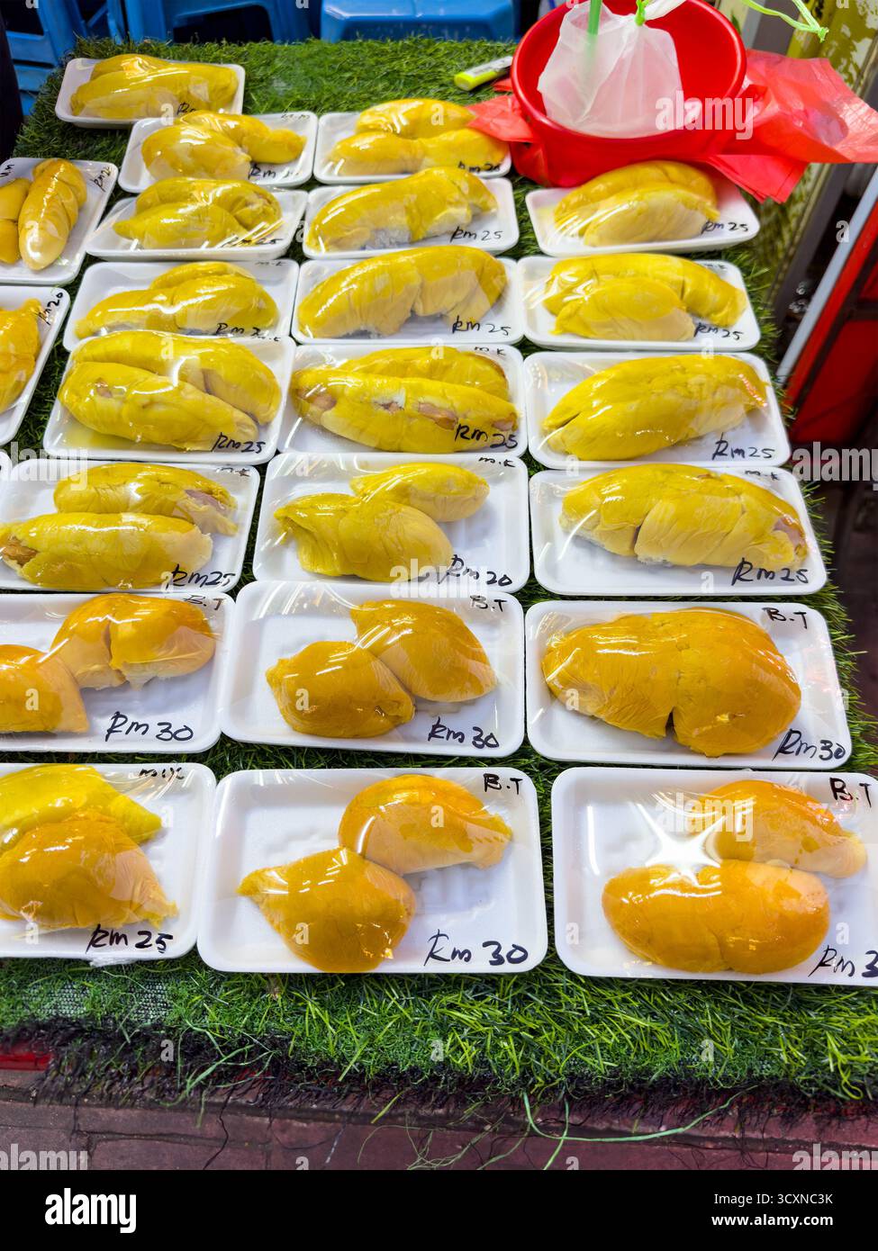 Reihen frischer Durian in Plastik gewickelt auf einem Straßenmarkt in jalan alor, Preise auf Paketen, stinkendes Obst kuala lumpur malaysia Stockfoto