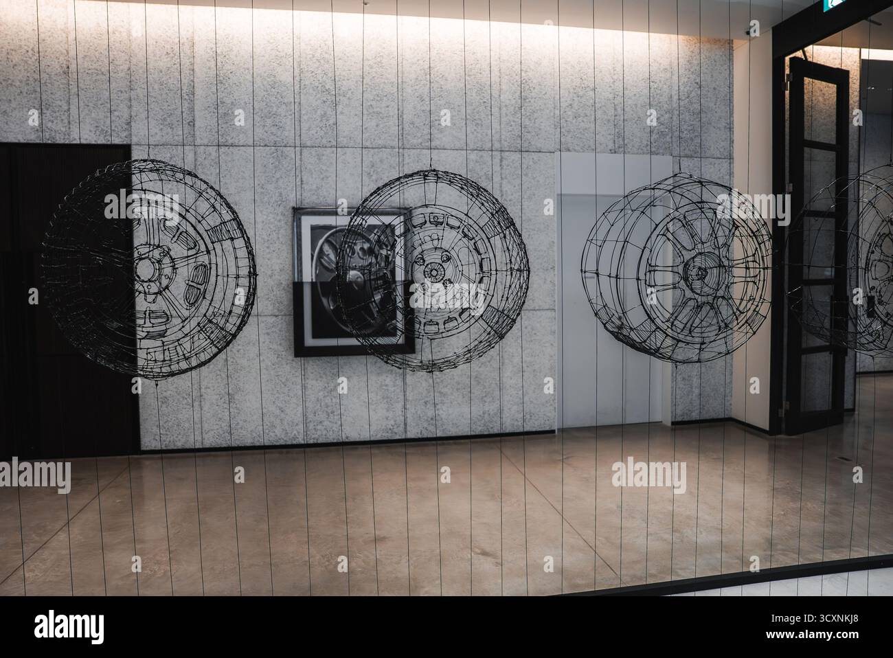 Moderner Korridor mit Kfz-Felgen und gerahmter Illustration Stockfoto