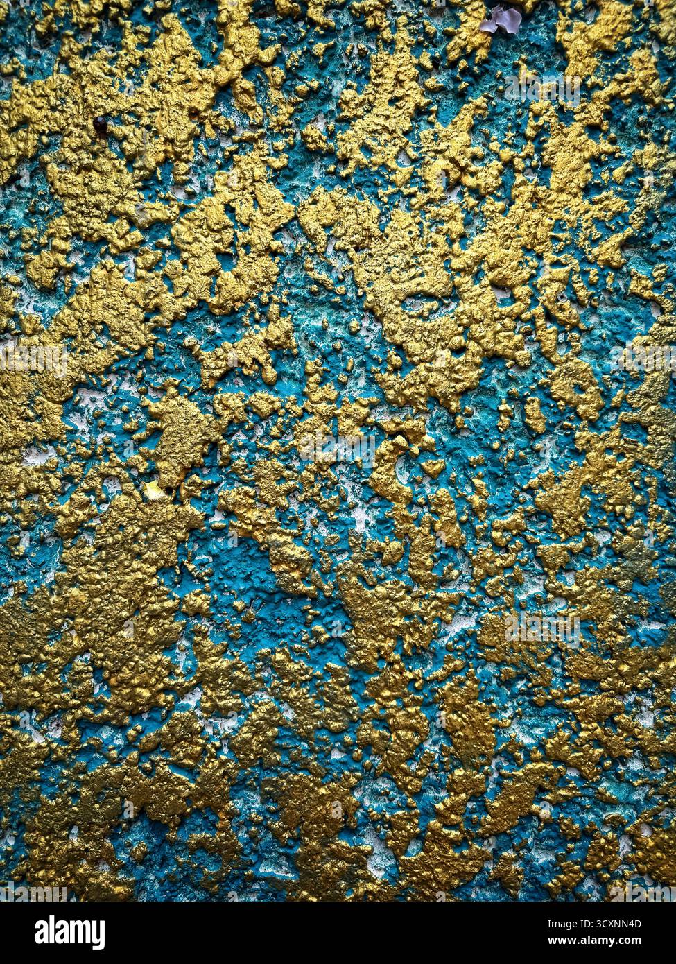 Nahaufnahme einer abstrakten, strukturierten Wand mit leuchtender blauer und goldener Farbe, die ein dynamisches und künstlerisches Muster erzeugt - Smartphone-aufgenommenes Stockfoto