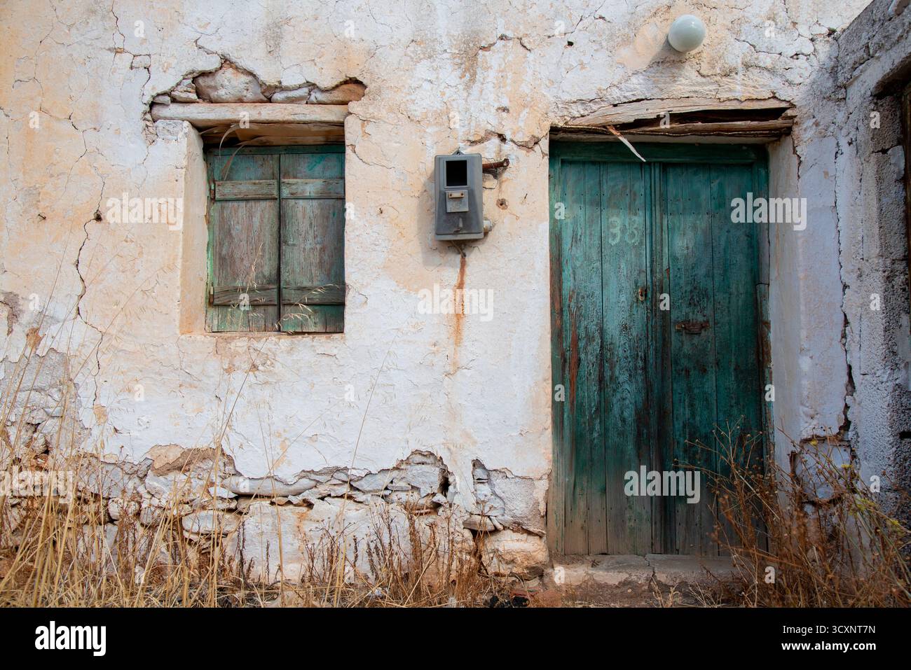 Verlassenes Haus mit abgenutzter Tür und Fenster in einem Dorf im Osten Kretas Stockfoto