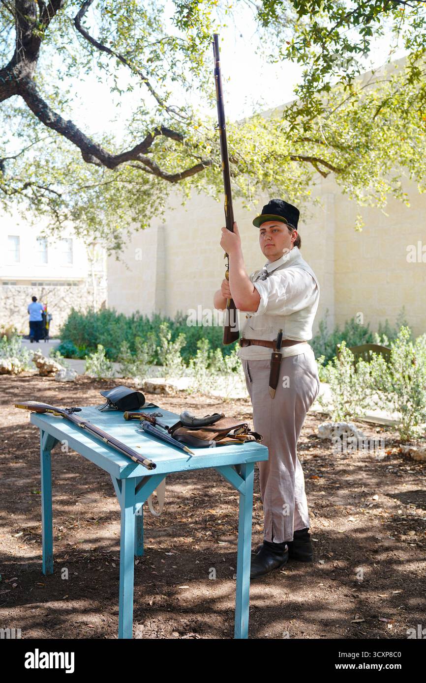 Ein Reenactor in historischen Gewändern hält eine Muskete während eines Lernprogramms zur Lebensgeschichte der Alamo Mission Stockfoto