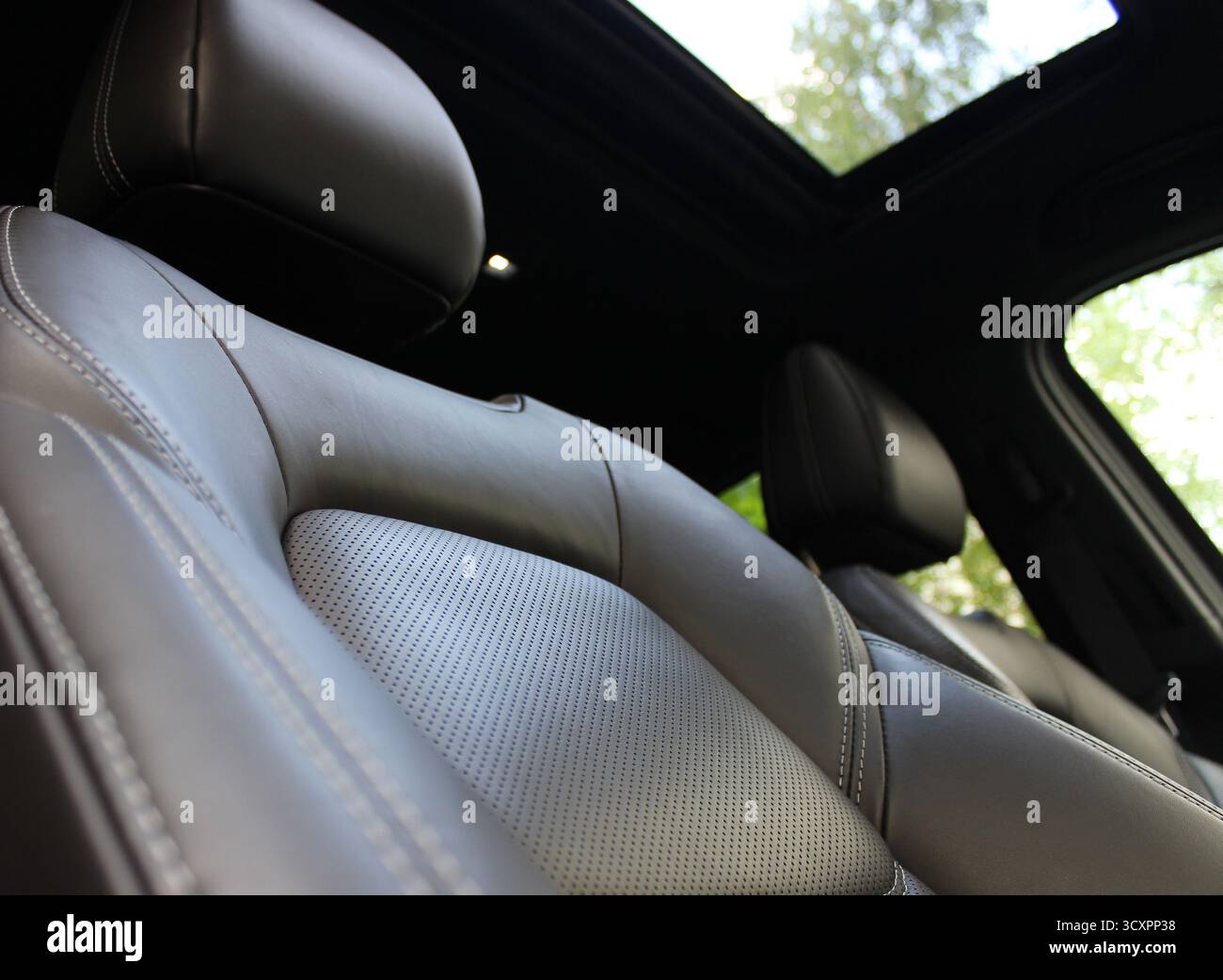 Die Rückenlehnen und Kopfstützen des anatomischen Autositzes, die mit hochwertigem Leder bedeckt sind, folgen den Konturen des menschlichen Körpers Stockfoto