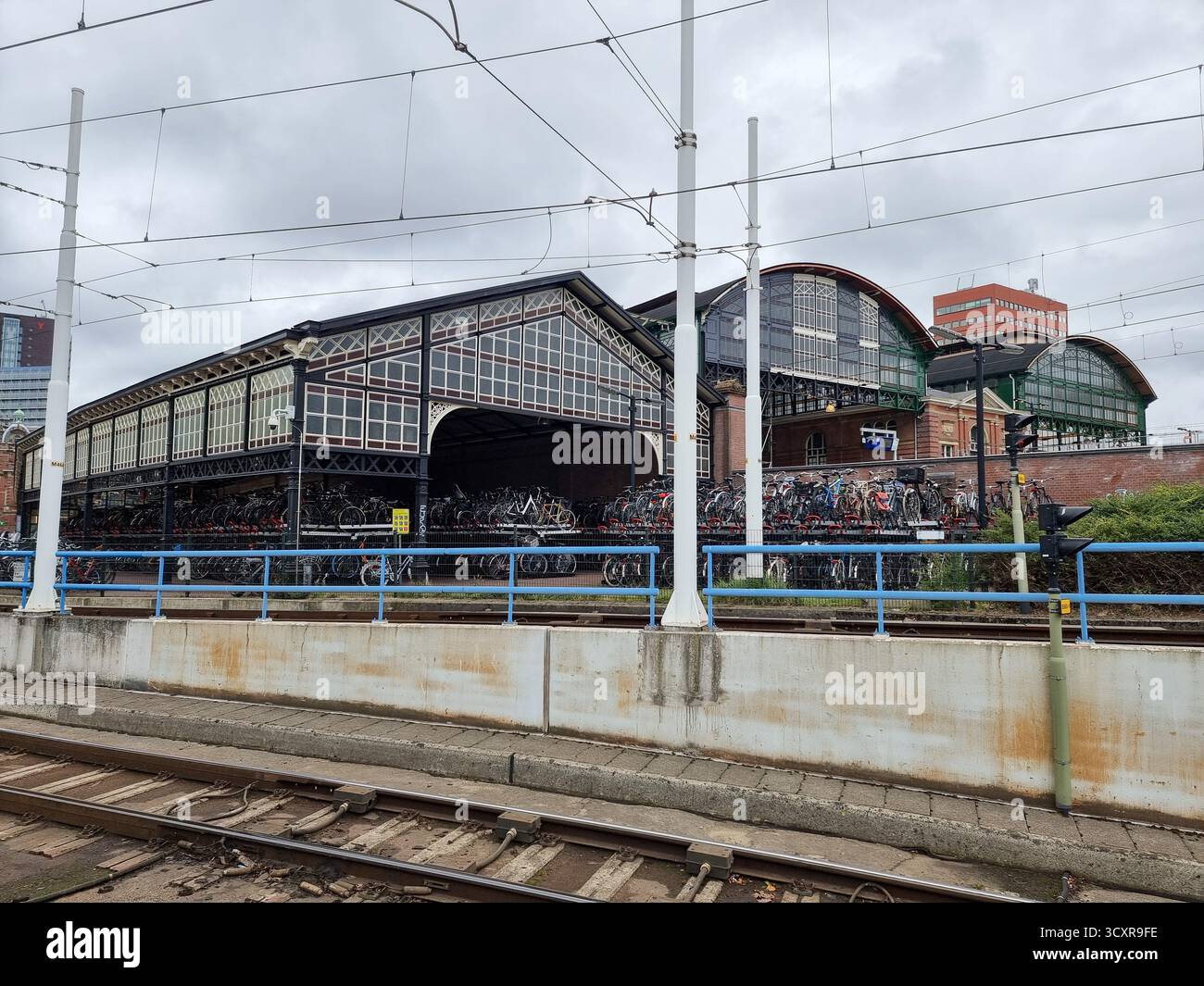 Überdachte Fahrradparkplätze im historischen Gebäude der Station Hollands Spoor in den Haag, Niederlande - Smartphone-aufgenommenes Stockfoto