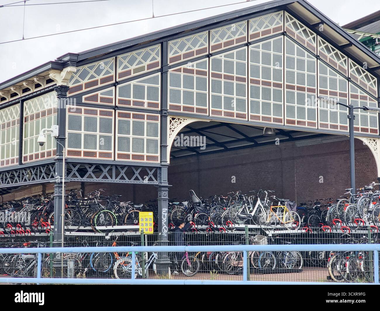 Überdachte Fahrradparkplätze im historischen Gebäude der Station Hollands Spoor in den Haag, Niederlande - Smartphone-aufgenommenes Stockfoto