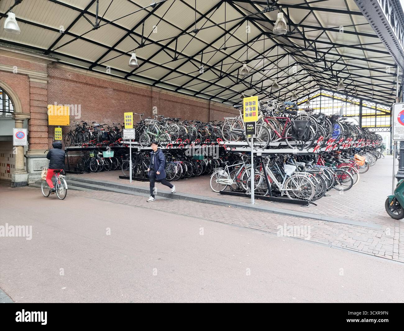 Überdachte Fahrradparkplätze im historischen Gebäude der Station Hollands Spoor in den Haag, Niederlande - Smartphone-aufgenommenes Stockfoto