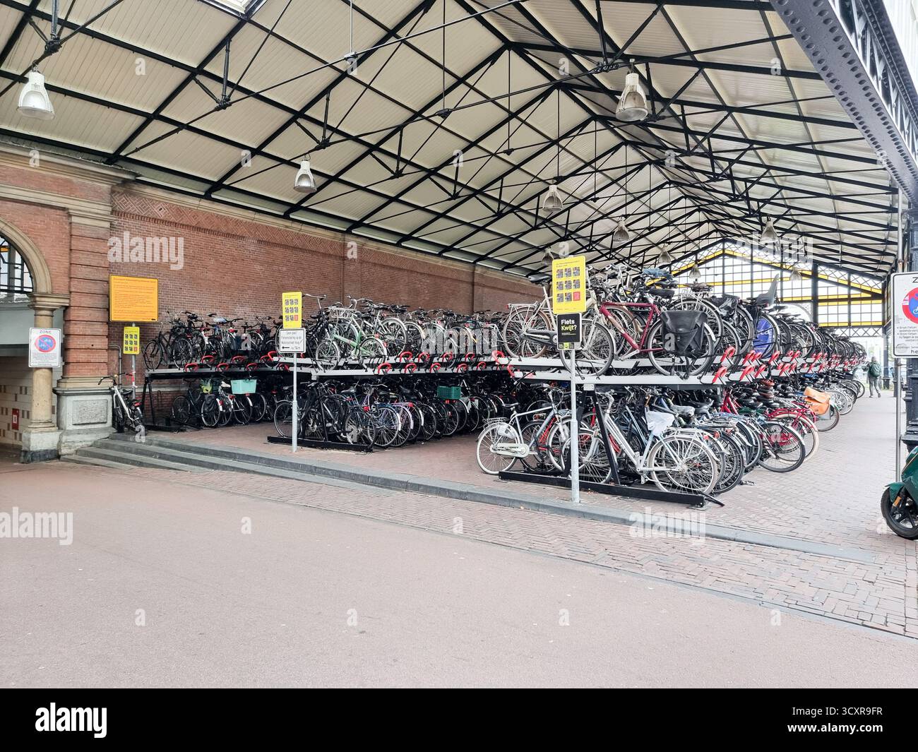 Überdachte Fahrradparkplätze im historischen Gebäude der Station Hollands Spoor in den Haag, Niederlande - Smartphone-aufgenommenes Stockfoto
