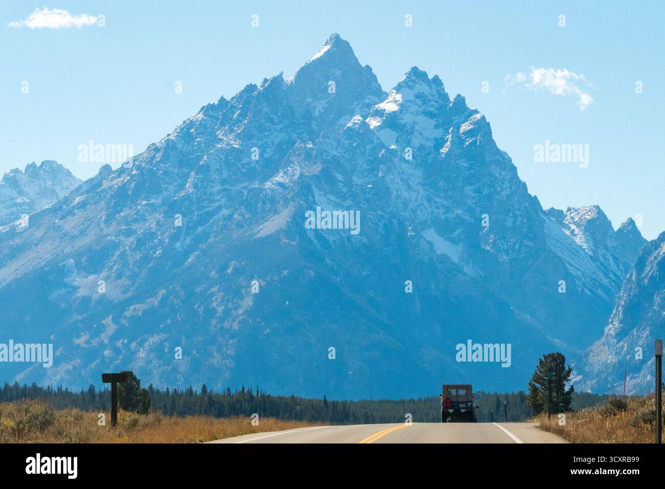 Teton Park Road im Grand Teton National Park, Wyoming, an einem klaren Herbsttag. Schneebedeckte Gipfel der Teton Range stehen majestätisch im Hintergrund Stockfoto