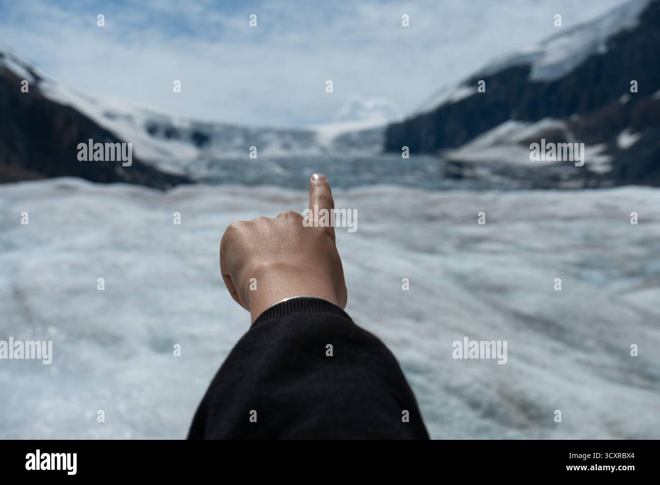 Er zeigt auf einen verschneiten Gletscher. Athabasca Glacier, Columbia Icefield, ab Stockfoto