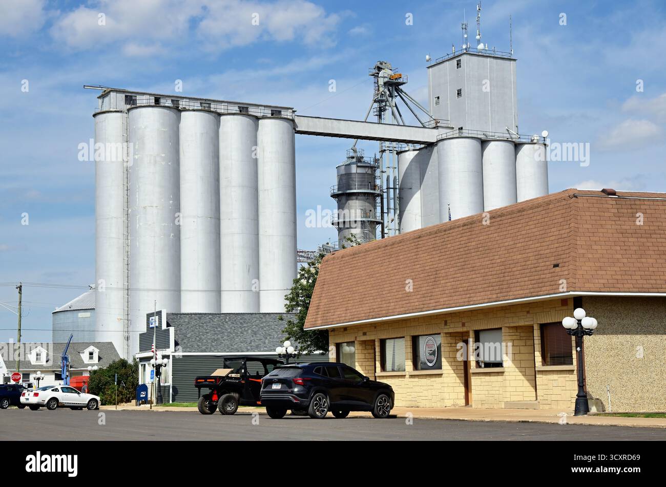 Ransom, Illinois, USA. Mehrere Getreideerhöhungen an einem großen Turm der Bauerngenossenschaft über einer kleinen Straße in Illinois. Stockfoto