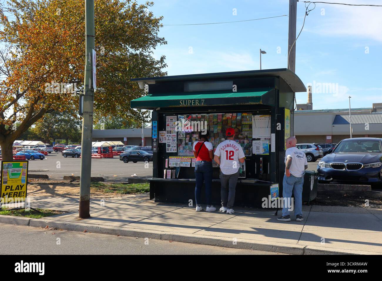 Personen, die Lottotickets an einem Zeitungskiosk neben einem Parkplatz in East Passyunk in Philadelphia, Pennsylvania kaufen. Stockfoto