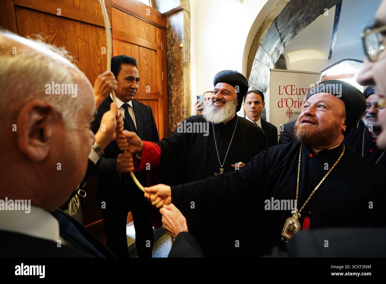 Patriarch Mor Ignatius Aphrem II. Von der syrisch-orthodoxen Kirche (C), Erzbischof Mor Nicodemus Daoud Sharaf (R), der syrisch-orthodoxe Erzbischof, Gouverneur von Ninive Abdul-Qader Al-Dakhil (2-L) und der Minister für Kultur, Tourismus und Antiquitäten Ahmed Fakkak Al-Badrani (L) läuten die Glocke der syrisch-orthodoxen Kirche St. Thomas während der Wiedereröffneten Zeremonie. Die Restaurierung der syrisch-orthodoxen Kirche St. Thomas aus dem 7. Jahrhundert war Teil der Initiative „Mosul Mosaic“, die das vielfältige kulturelle Erbe der Stadt bewahren sollte. Das Projekt begann 2019, Stockfoto