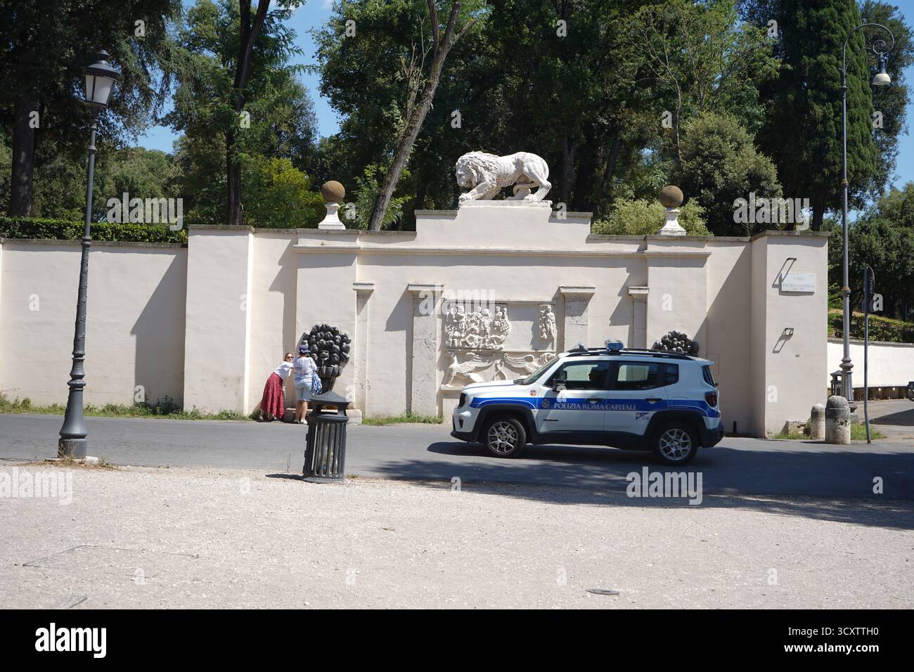 Ein SUV „Polizia Roma Capitale“, der neben einer klassischen Mauer mit einer Löwenstatue parkt, neben den Gärten der Villa Borghese in Rom, Italien. Stockfoto