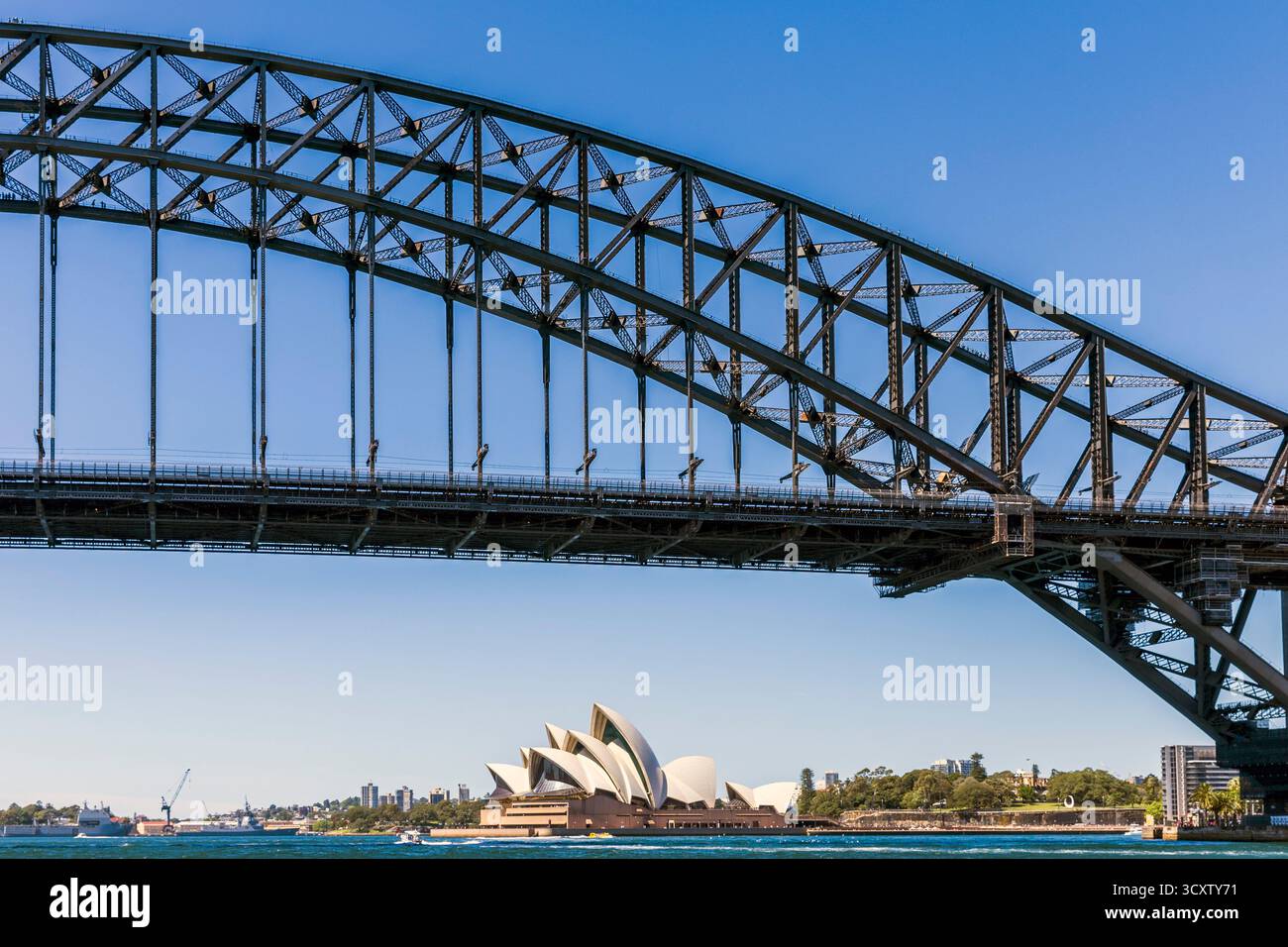 Legendäres architektonisches Meisterwerk Sydney Opera House mit seinem einzigartigen segelähnlichen Design an einem sonnigen Nachmittag, umrahmt von der Harbour Bridge, Sydney, Stockfoto