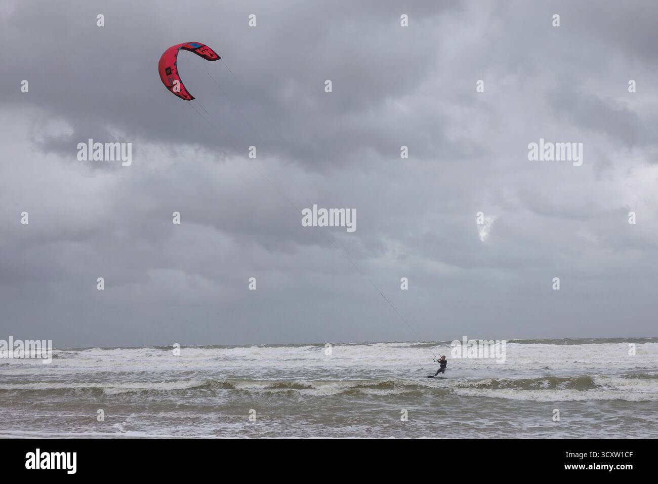 Kitesurfer an einem grauen Herbsttag in Oostkapelle auf Walcheren, Zeeland, Niederlande. Kitesurfer an einem grauen Herbsttag bei Oostkapelle auf Walcheren, Stockfoto