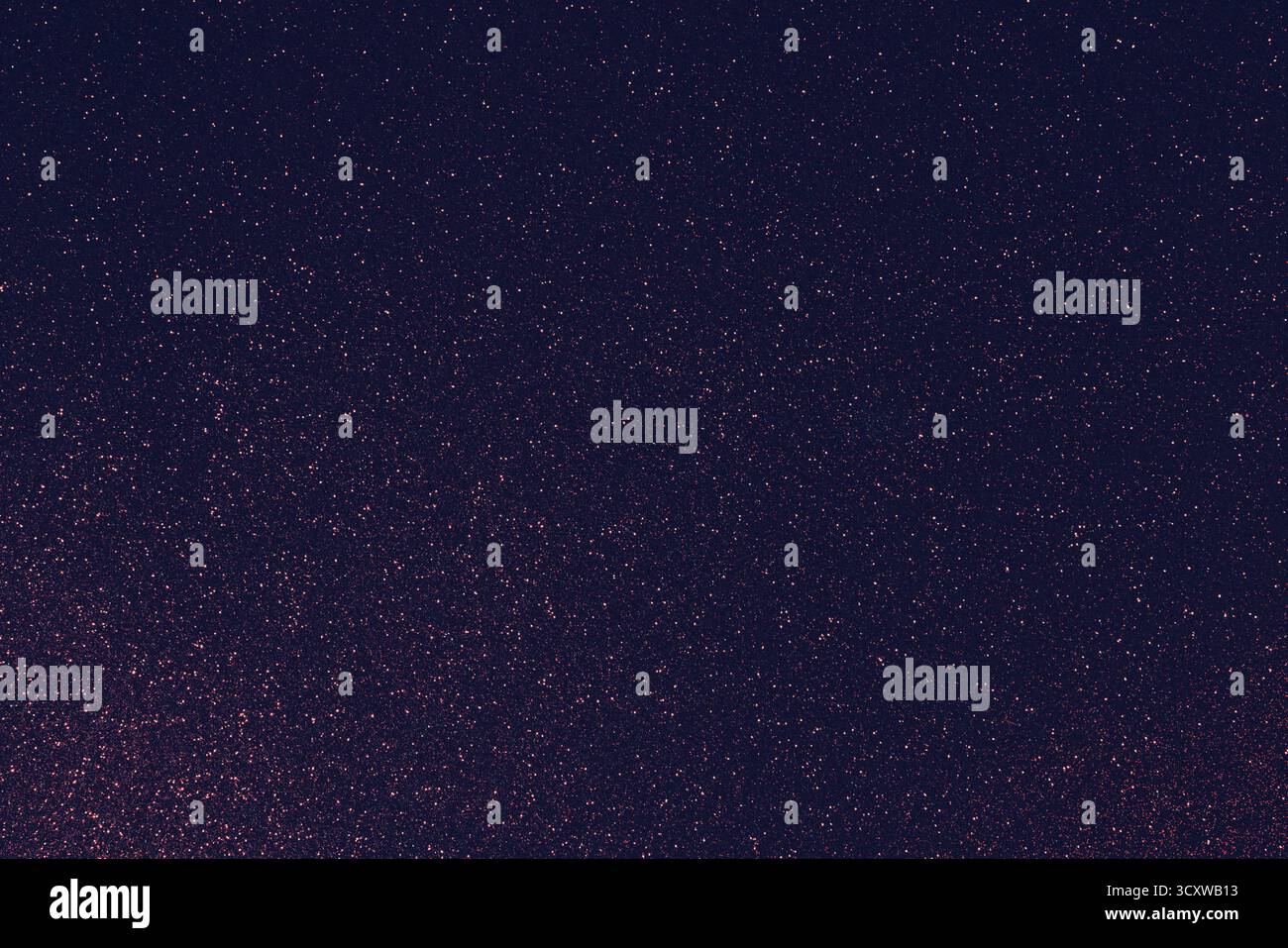 Granulierter, dunkel-violetter Glitzerhintergrund mit leuchtend roten Funkeln und dezenten blauen Schattierungen sorgen für einen stimmungsvollen Kontrast auf detaillierter abstrakter Oberfläche Stockfoto