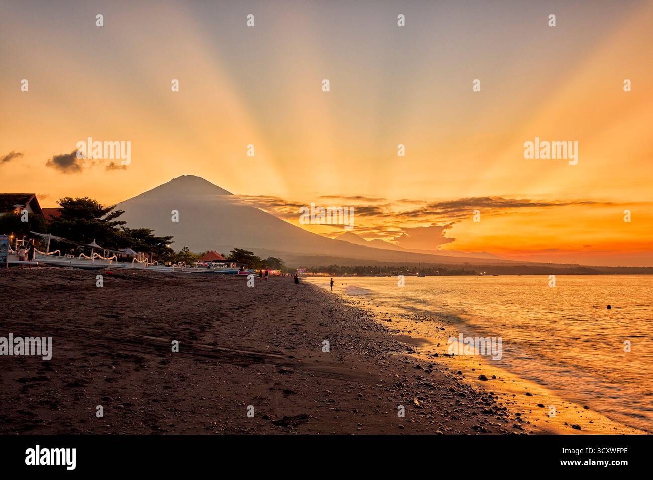 Malerischer Blick auf den Vulkan Mount Agung und den Amed Beach bei Sonnenuntergang. Amed, Karangasem Regency, Bali, Indonesien. Stockfoto