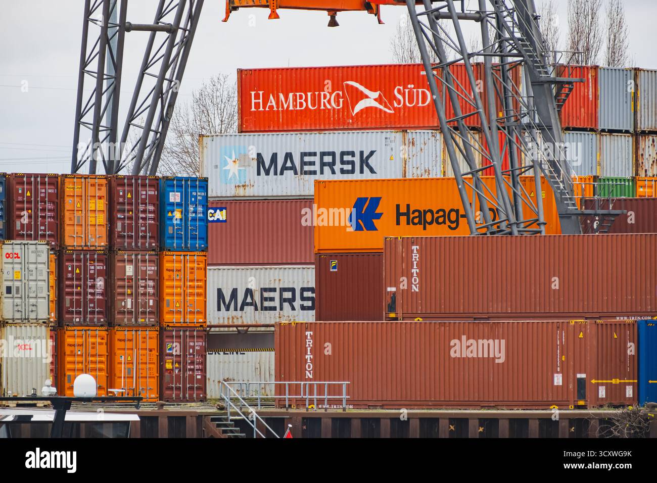 In einem geschäftigen Hafen sind Stapel von farbenfrohen Schiffscontainern angeordnet, die eine lebendige Industrieszene schaffen Stockfoto