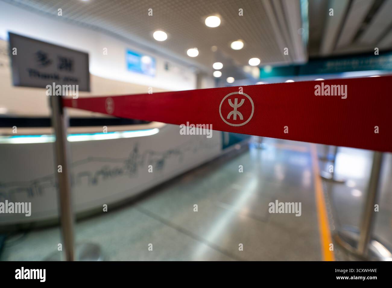 Hongkong, China - 19. September 2025: Nahaufnahme des MTR-Logos (Mass Transit Railway) auf einem roten, einziehbaren Schrankengürtel in der Nähe des Stockfoto