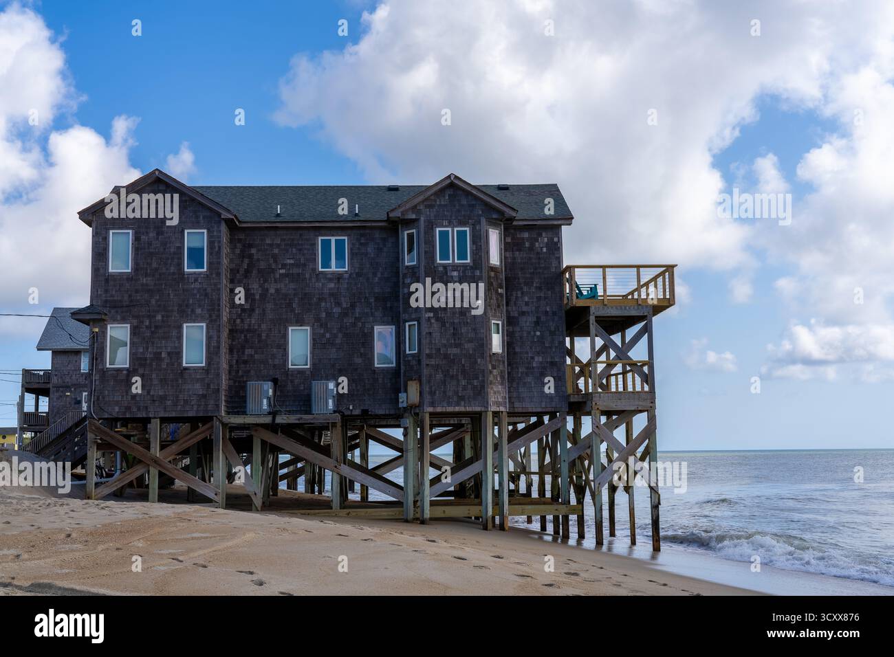 Rodanthe North Carolina: 17. Juli 2022: Ein Strandhaus in Rodanthe, das direkt an der Küste liegt, mit Anhäufungen im Meer aufgrund der Erosion des Strandes Stockfoto