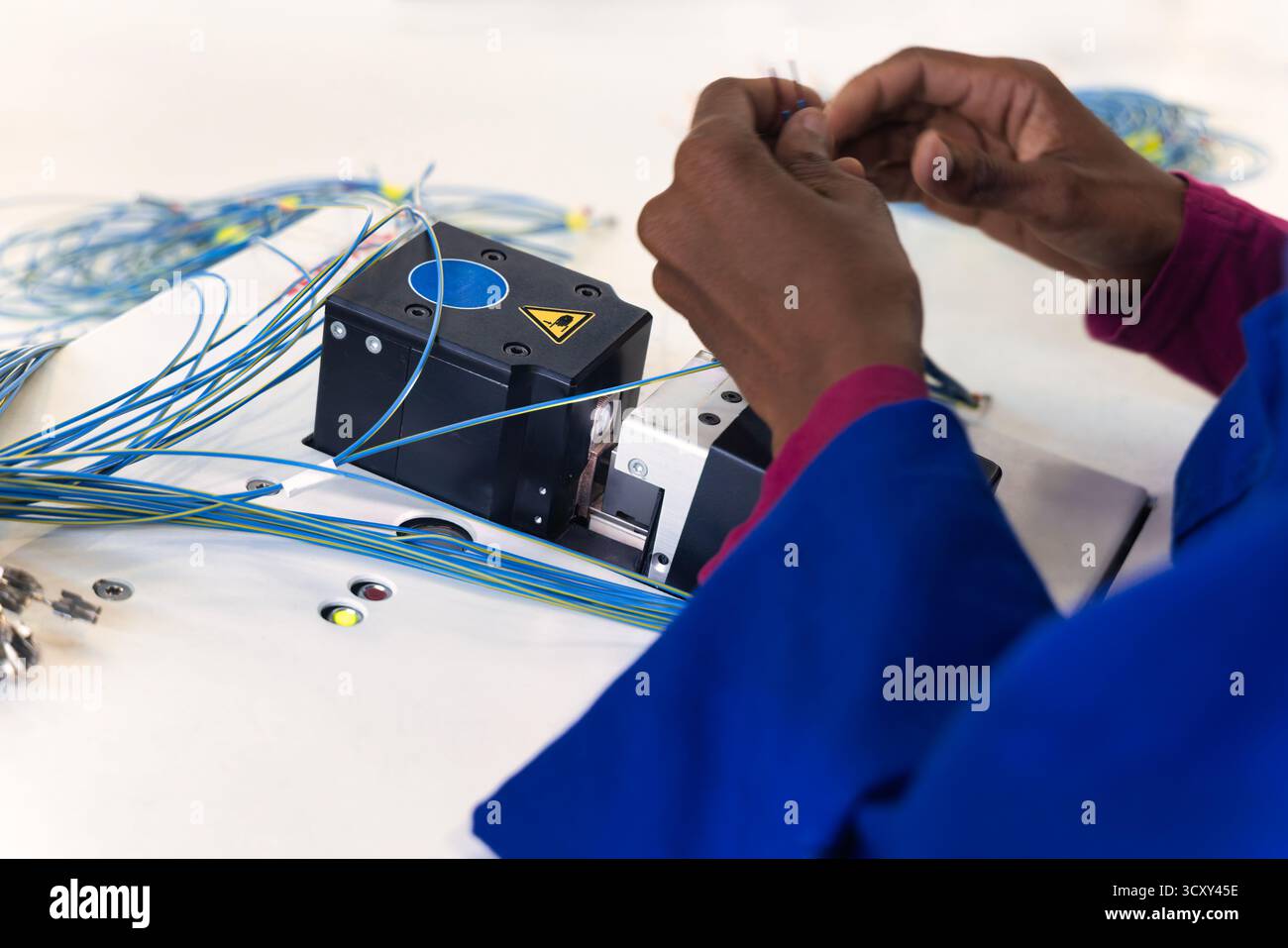 afroamerikanischer Arbeiter in einer Elektrofabrik für Kabelbaumhersteller, Stockfoto