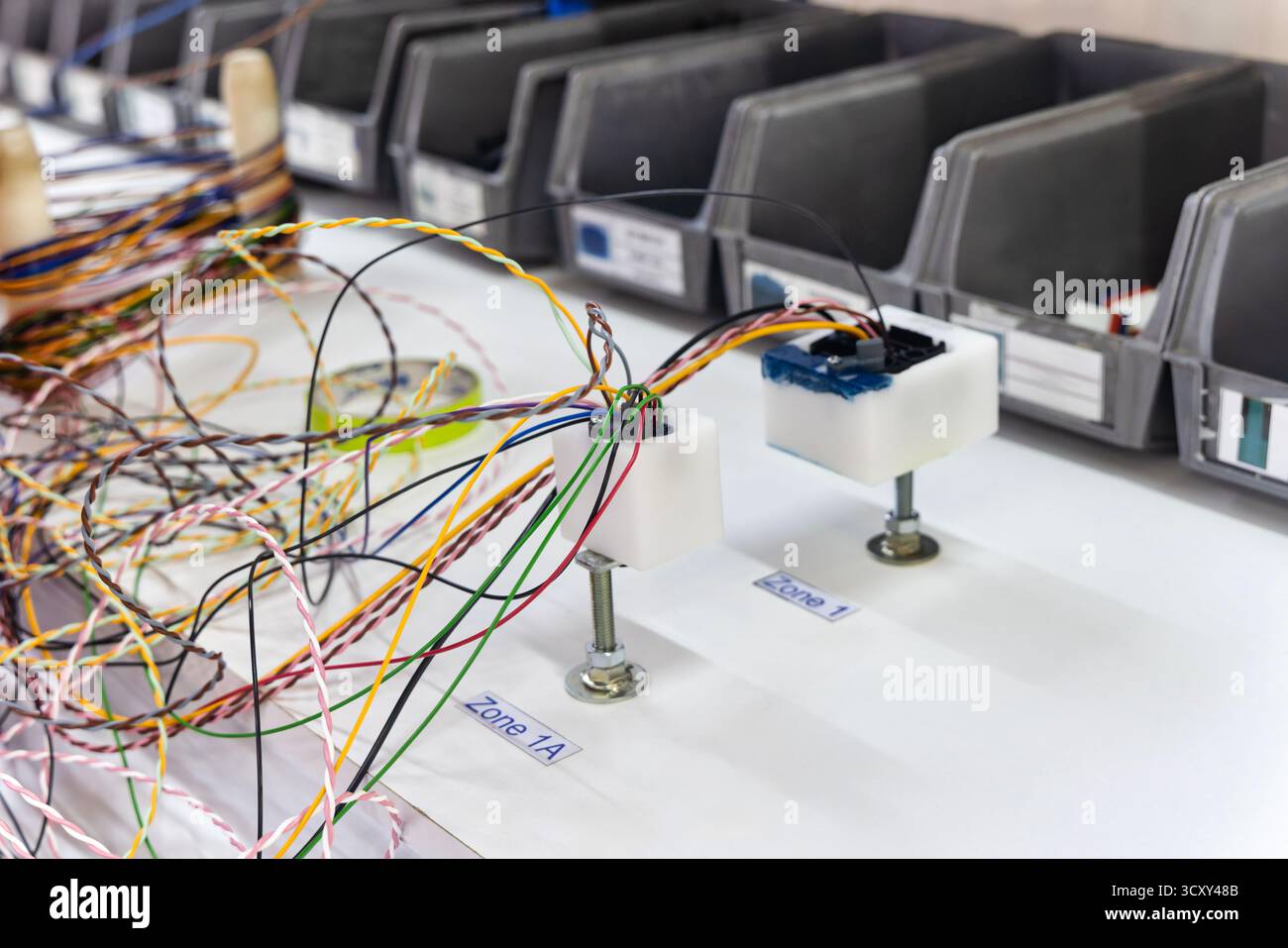 Fabrik für elektrische Kabelbäume in der Automobilindustrie, die Verkabelung und die Steckverbinder auf einem Vorlagenfeld durchführen Stockfoto