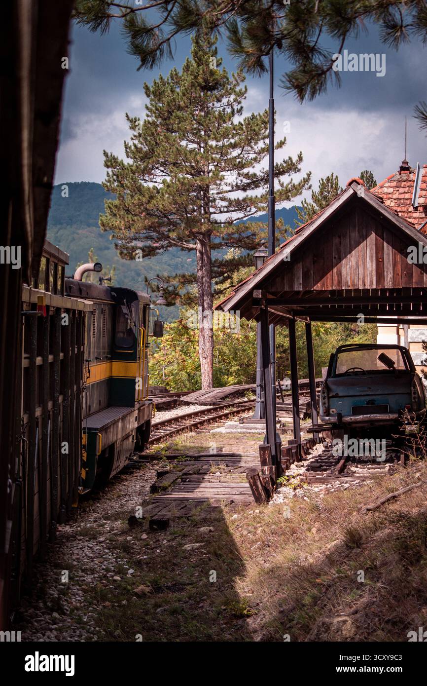 Die Sargan Eight in Serbien. Eine Schmalspurbahn, die aus dem Dorf Mokra Gora führt. Ein hölzerner Unterstand, unter dem ein altes, verlassenes Auto steht. Stockfoto