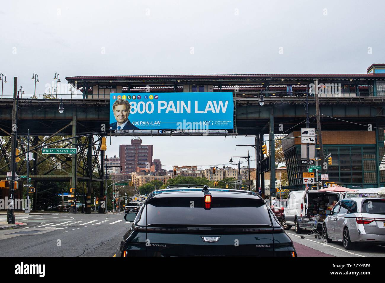 Werbung für einen Anwalt, der sich auf Schmerz- und Verletzungsrecht spezialisiert hat, Plakate auf erhöhten U-Bahn-Gleisen in der Bronx, New York City oberhalb der Stadtstraße Stockfoto
