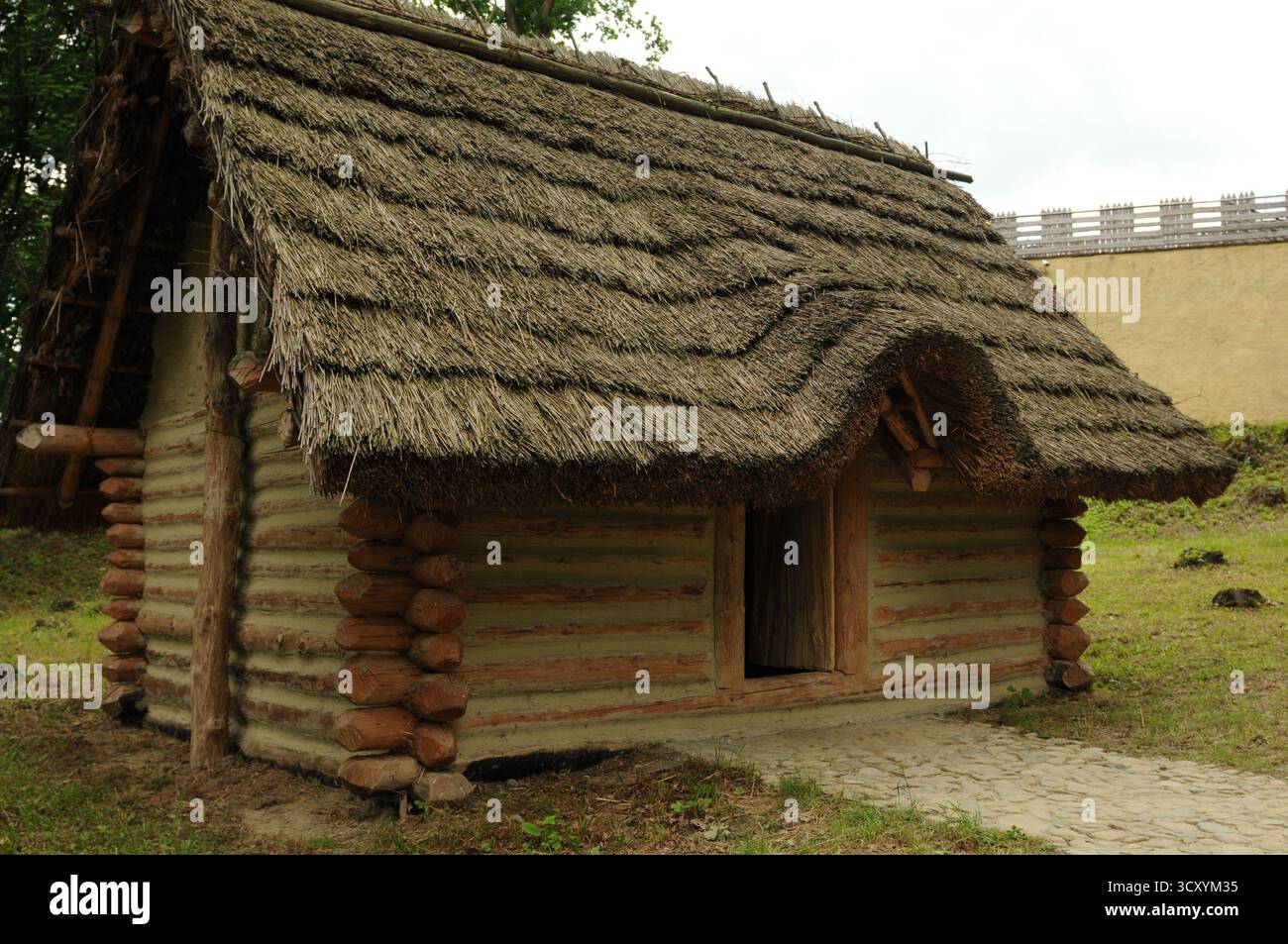 Rekonstruiertes frühmittelalterliches Blockhaus mit Strohdach im archäologischen Freilichtmuseum Karpacka Troja in Trzcinica bei Jasło, Subkarpaten, Stockfoto