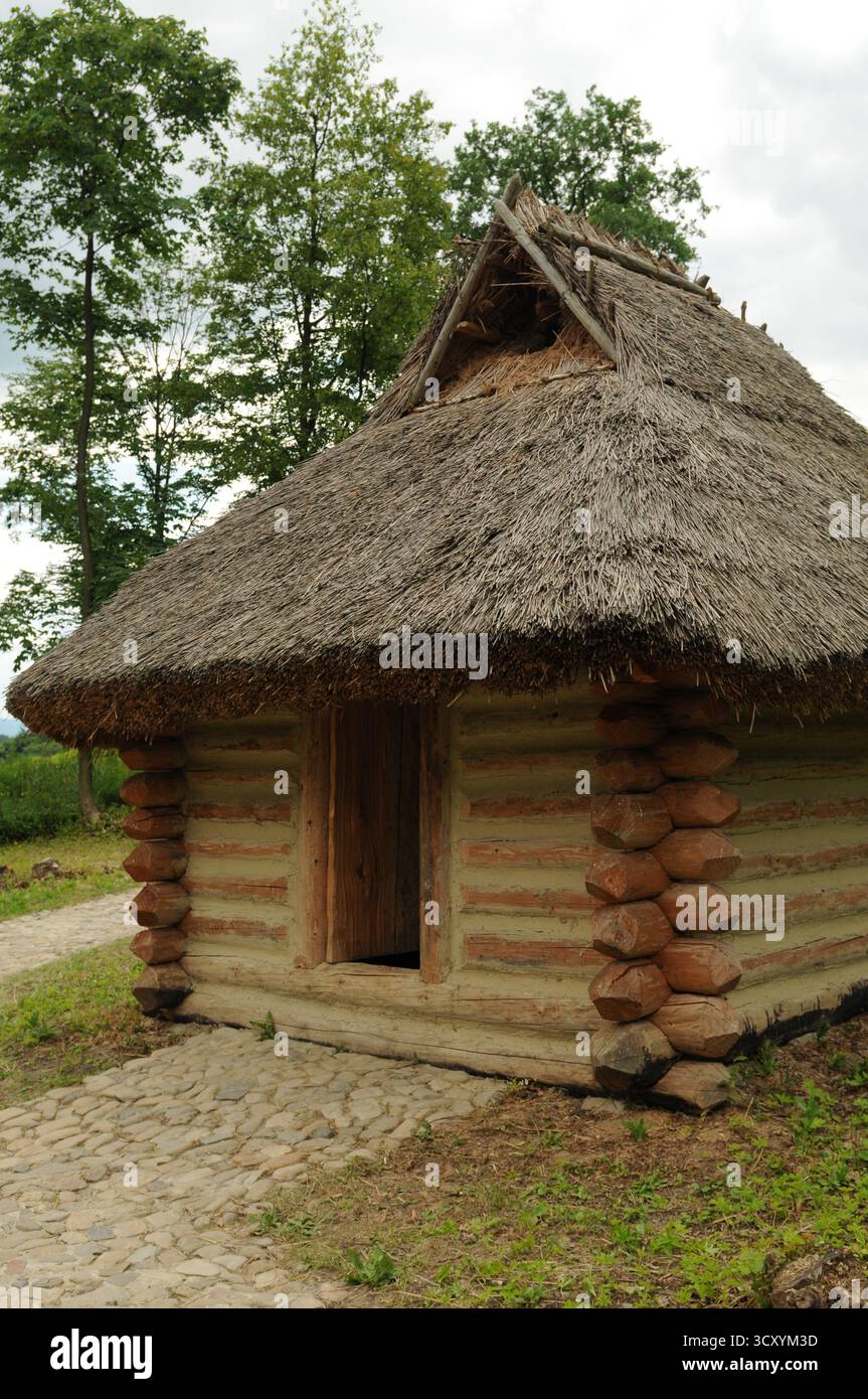 Rekonstruierte frühmittelalterliche Holzhütte mit Strohdach im archäologischen Freilichtmuseum Karpacka Troja in Trzcinica bei Jasło, Subkarpaten, Stockfoto