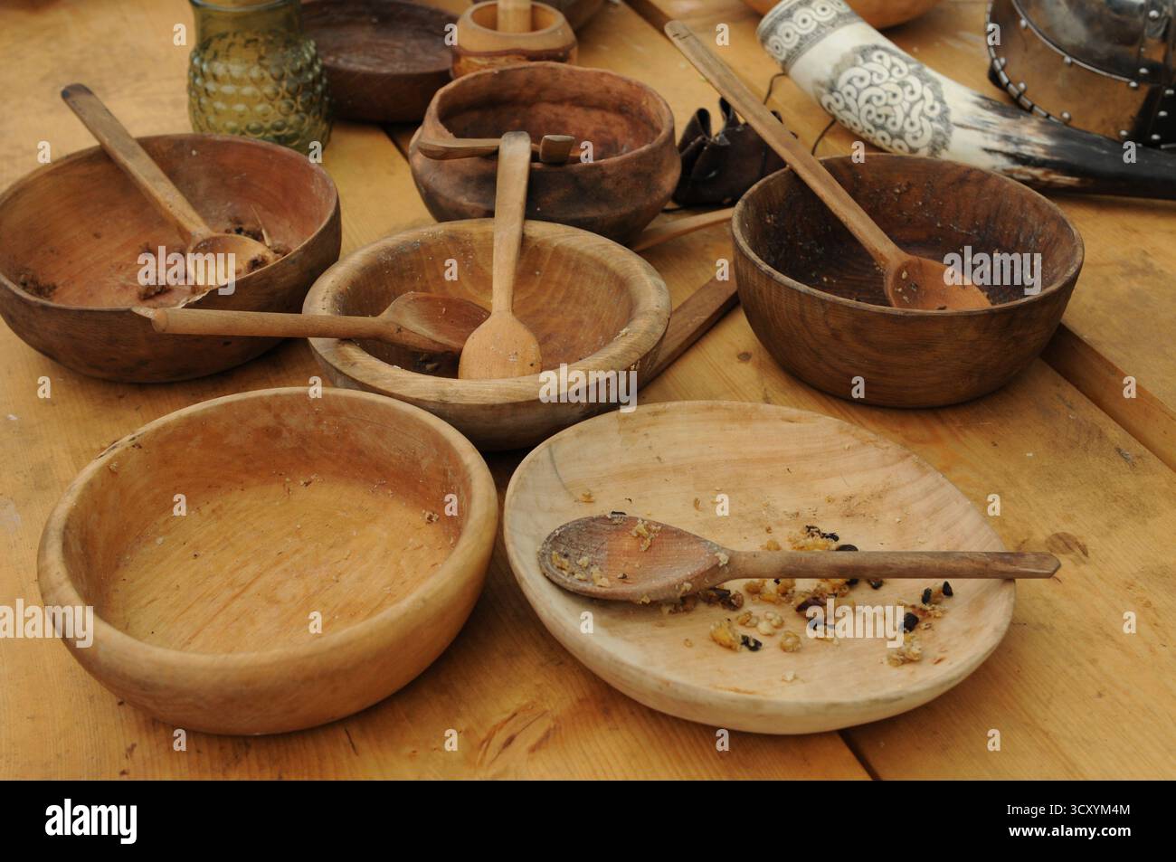 Holzschüsseln und Löffel nach einer Mahlzeit, Teil einer frühmittelalterlichen Rekonstruktion des Lebensstils in Trzcinica, Subkarpaten, Polen. Stockfoto