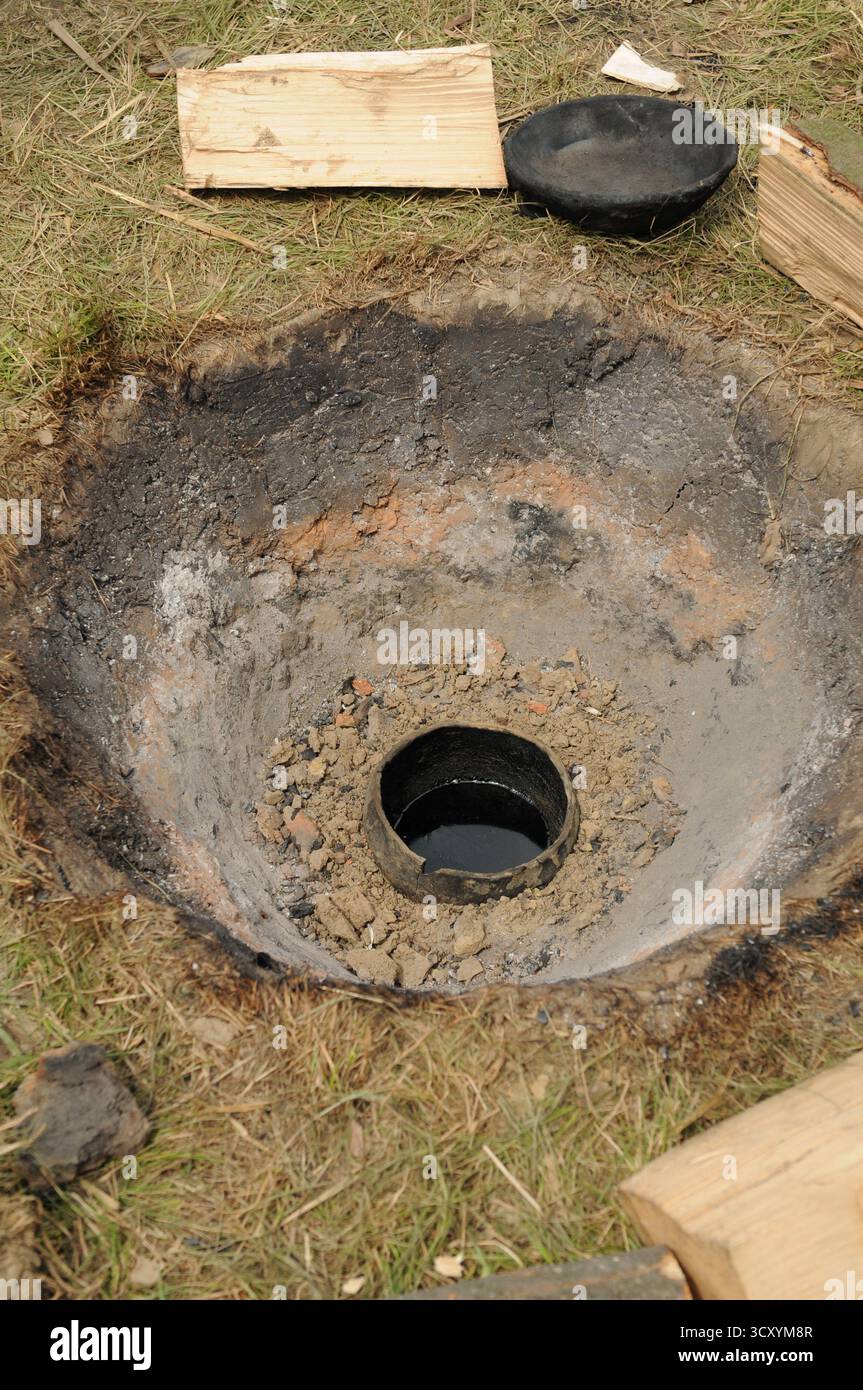 Tongrube, die für die traditionelle Teerherstellung während einer frühmittelalterlichen Rekonstruktion von Handwerken in Trzcinica, Subkarpaten, Polen, verwendet wurde. Stockfoto