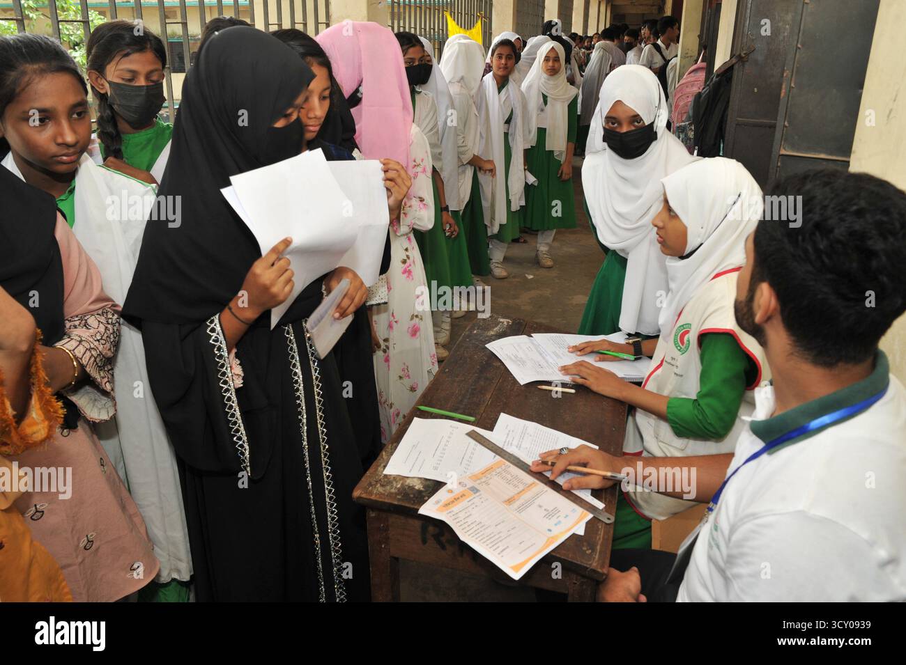 Chattogram, Bangladesch. Oktober 2025. Die Schüler der Rahmania Secondary School stellen sich an, um sich gegen Typhus impfen zu lassen. Zum ersten Mal hat die Regierung von Bangladesch ein nationales Typhus-Impfprogramm gestartet. Die Kampagne zielt darauf ab, rund 49 Millionen Kinder und Jugendliche zwischen 9 Monaten und 15 Jahren kostenlos gegen Typhus zu impfen. Am 16. Oktober 2025 in Chittagong, Bangladesch. (Foto: MD Rafayat Haque Khan/Eyepix Group/SIPA USA) Credit: SIPA USA/Alamy Live News Stockfoto