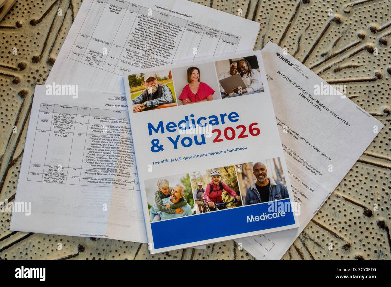 Stillleben des offiziellen Handbuchs Medicare & You 2026 und des Planabbruchschreibens von Aetna, USA 2025 Stockfoto