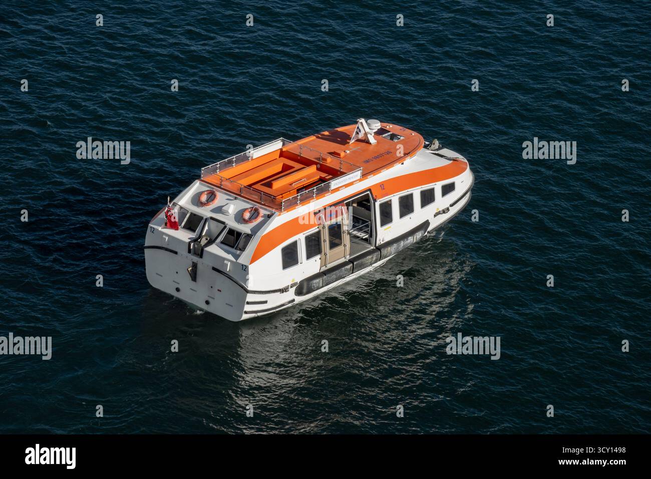 Newport, RI - USA - 3. Oktober 2025 das in weiß und orange leuchtende Rettungsboot der Enchanted Princess Tender schwimmt vor Newports Hafen auf ruhigem, blauem Wasser unter klarem Wasser Stockfoto