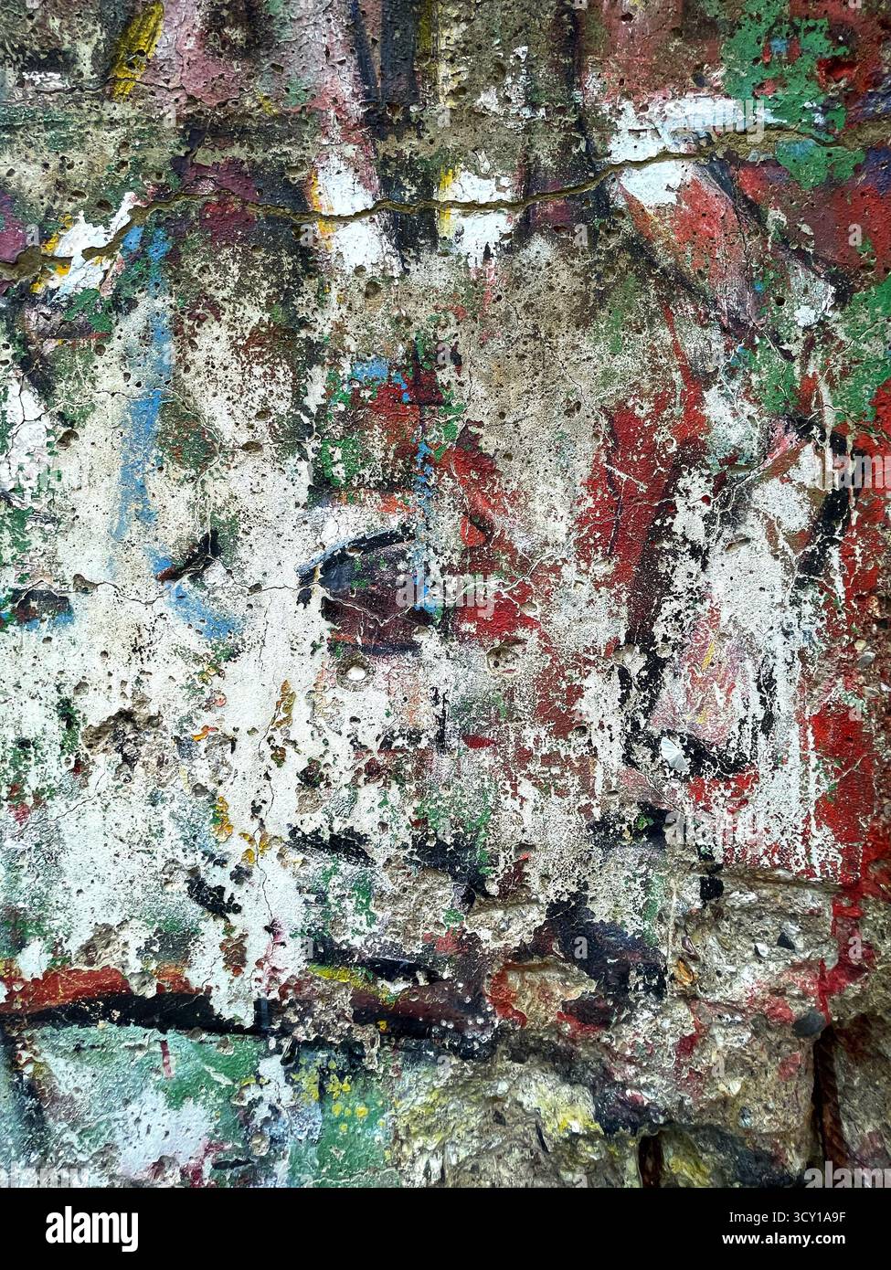 Farbenfrohe abstrakte Graffiti-Textur auf einer Betonwand mit Farbschichten und sichtbaren künstlerischen Pinselstrichen Stockfoto
