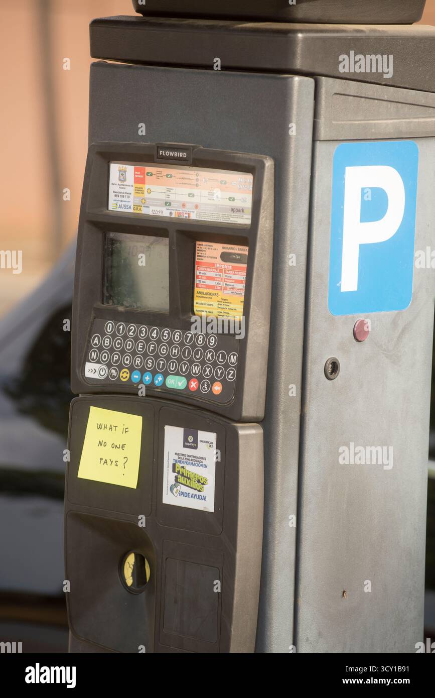 Ein Parkzähler in der Stadt Huelva mit einem Post-it, der besagt: Was passiert, wenn niemand für den Parkzähler oder die blaue Zone bezahlt? Stockfoto