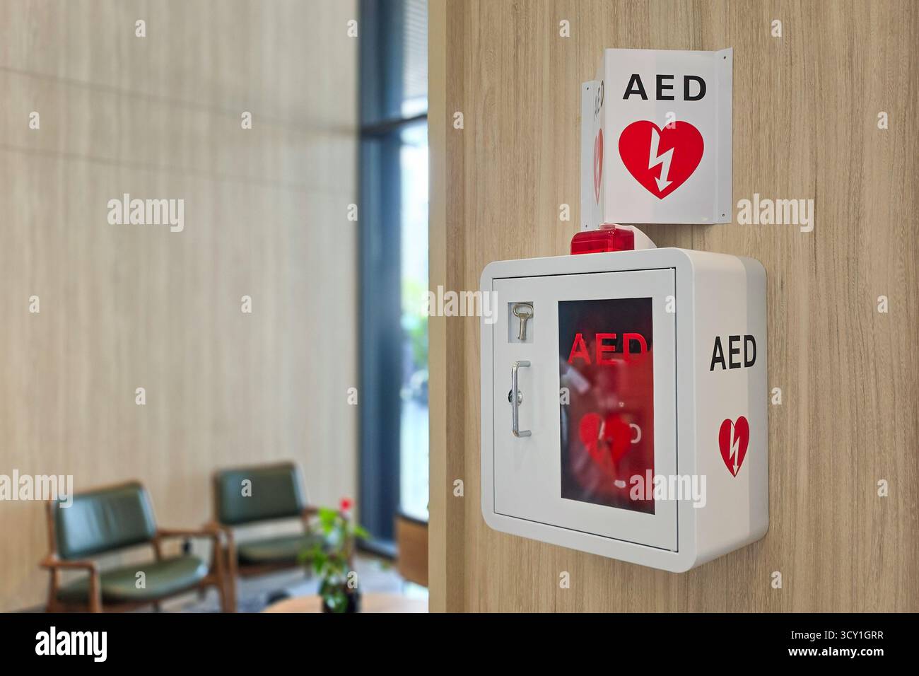 AED oder automatisierter externer Defibrillator, der als erste Hilfe bei Herzinfarkt an der Wand in der Hotellobby installiert ist. Stockfoto