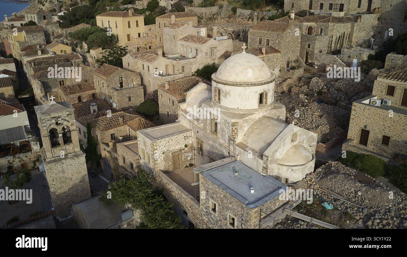 Blick auf die Drohne, aus der Vogelperspektive auf Kirchen und Steinhäuser im traditionellen Dorf mit Vegetation, Monemvasia, Monemvassia, Malvasy, kleine byzantinische Stadt, r Stockfoto