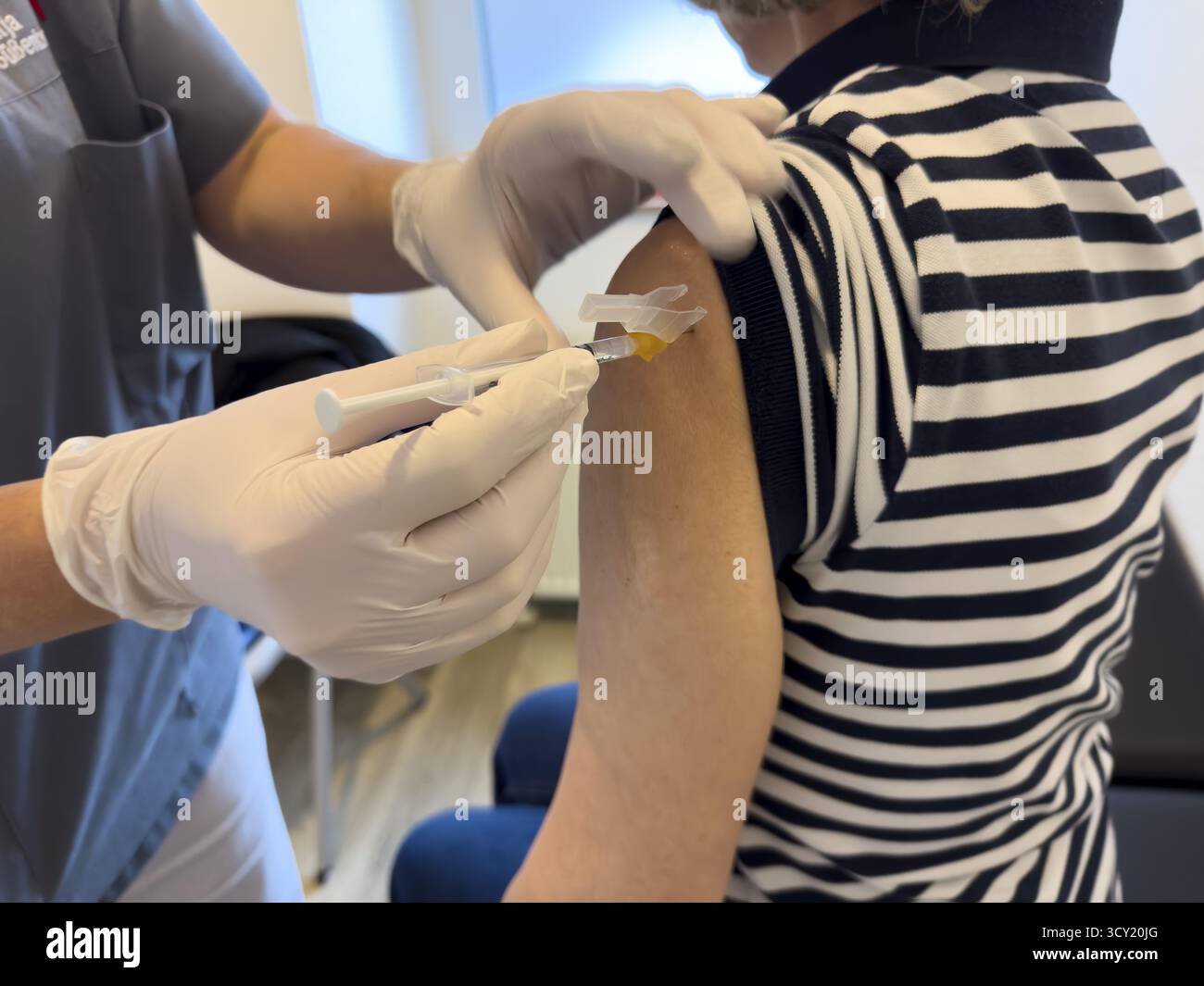 Patientin erhält Injektion in den Oberarm zur Impfung gegen ansteckende Krankheit Grippe Grippe Impfung Grippe Schutz gegen Influenzavirus in Stockfoto