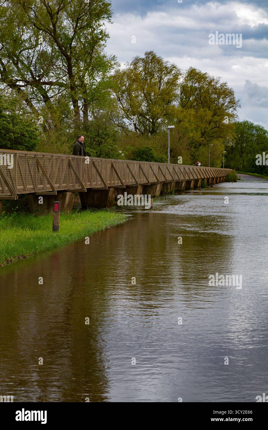 Mann auf der Fußgängerbrücke in Sutton Gault überflutet, 2012 Stockfoto