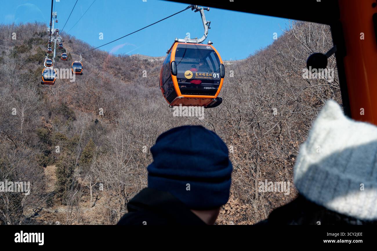 Orangefarbene Seilbahnen gleiten den Berg hinauf zur Chinesischen Mauer im Norden Pekings Stockfoto