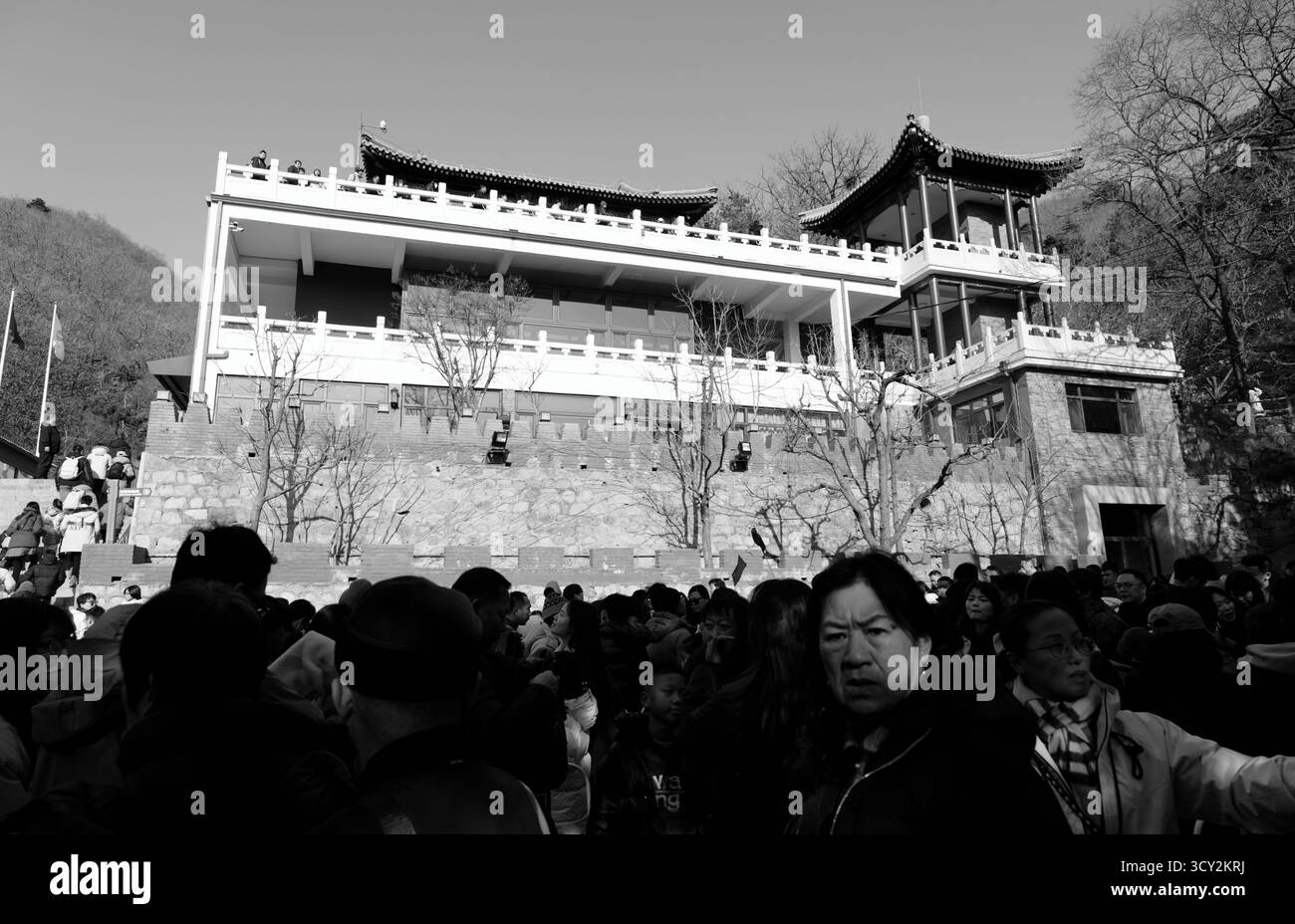 Am Eingang der Chinesischen Mauer in Peking versammelt sich die Menschenmenge unter einem mehrstöckigen Gebäude mit traditionellen chinesischen Architekturelementen Stockfoto