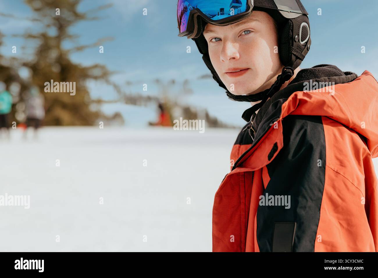 Nahaufnahme des Snowboarders in roter Jacke und Skibekleidung Stockfoto