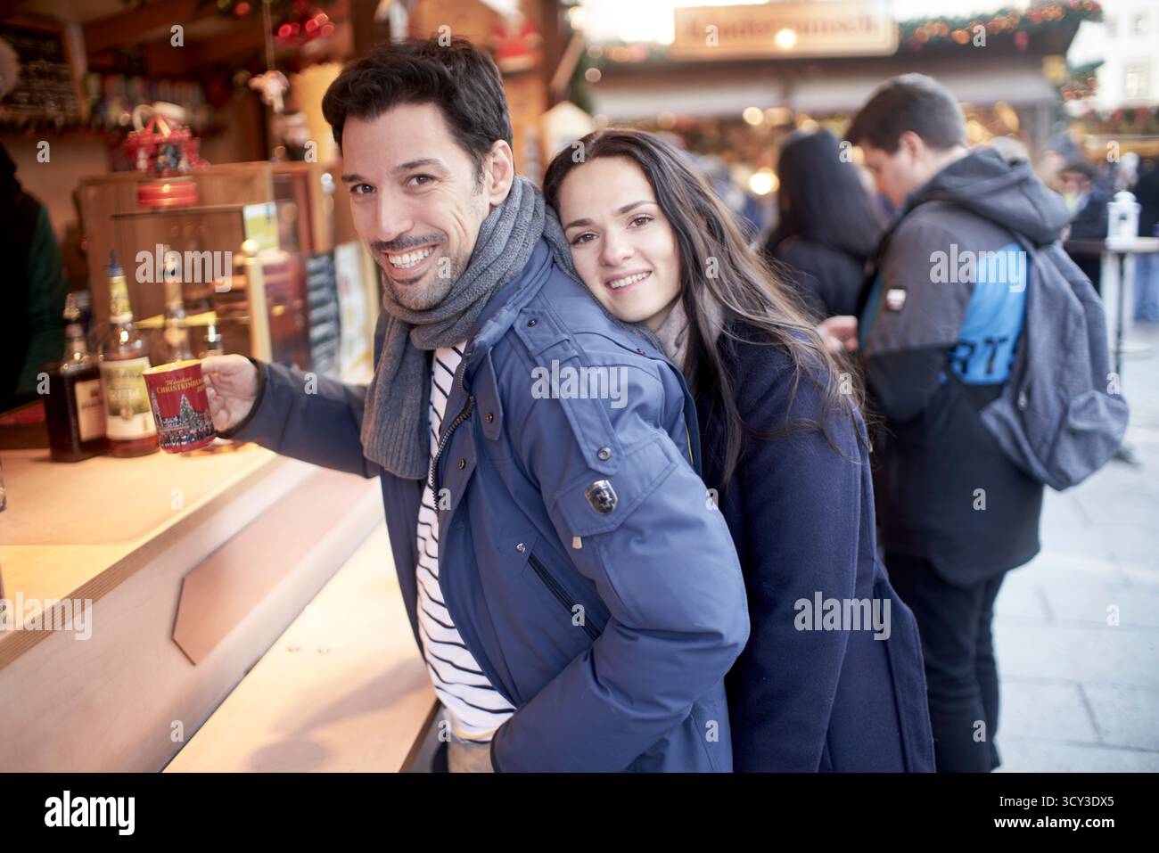 Paare auf dem weihnachtsmarkt kaufen Obstpunsch oder heißen Gewürzwein Stockfoto