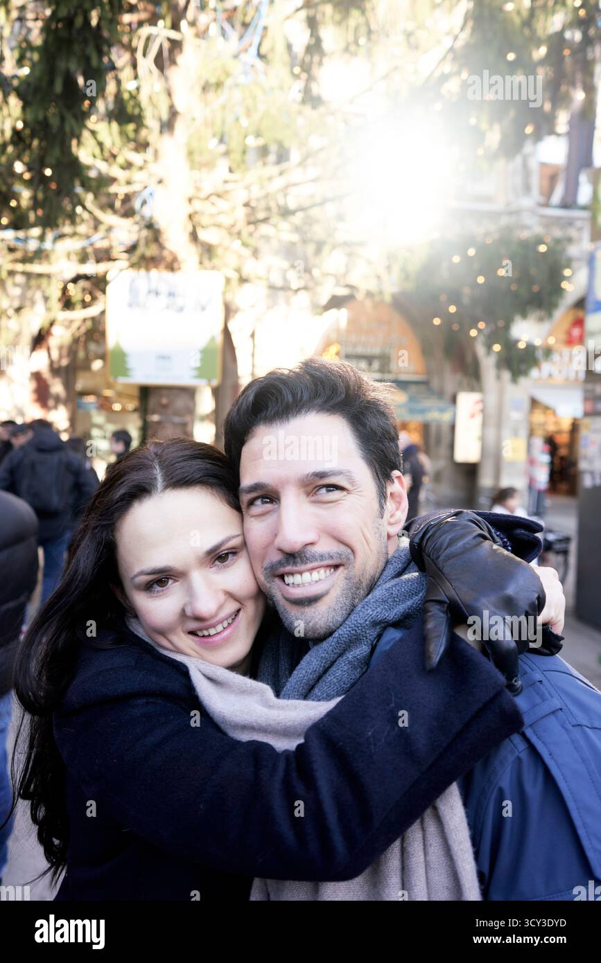 Glückliches Paar in Winterkleidung in der Stadt mit weihnachtsdekoration Stockfoto